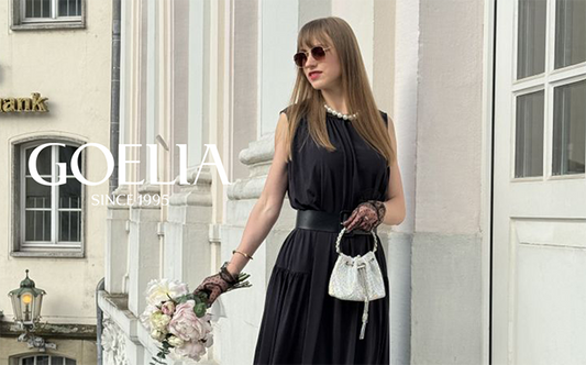 A lady with long hair wears a black dress in summer.