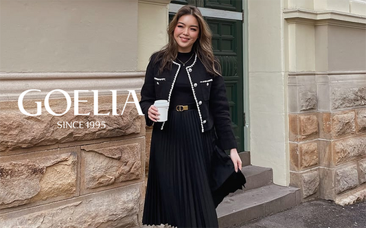 a lady in black tweed jacket with black midi pleated dress 