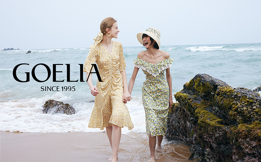 2 ladies wearing dresses walking on the beach 