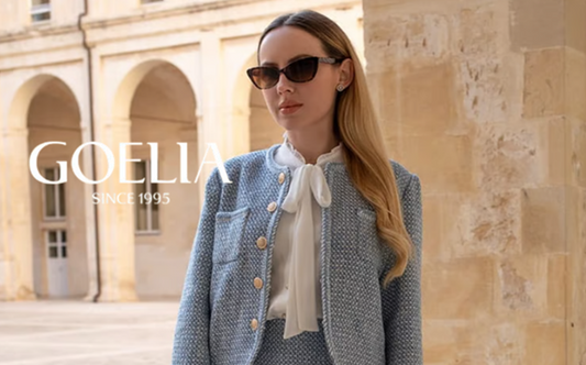 a lady in a white bow tie neck shirt and a blue suit jacket