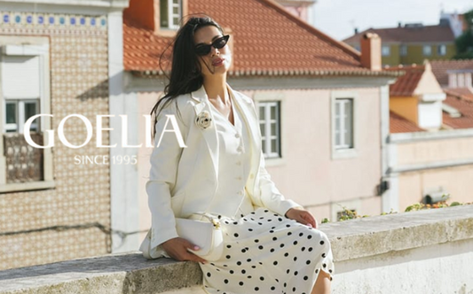 a lady in a white vest, a white blazer and a white skirt with black polka dots