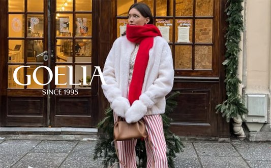 a lady wears a white teddy jacket with a red scarf 