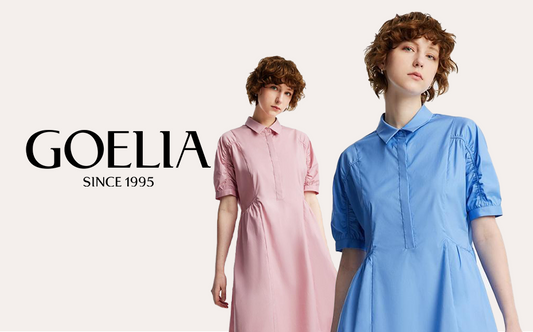 Two girls with curly hair one is wearing a pink shirt dress and the other is wearing a blue shirt dress.